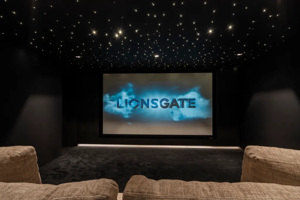 The home cinema screen glowing beneath the star-lit ceiling