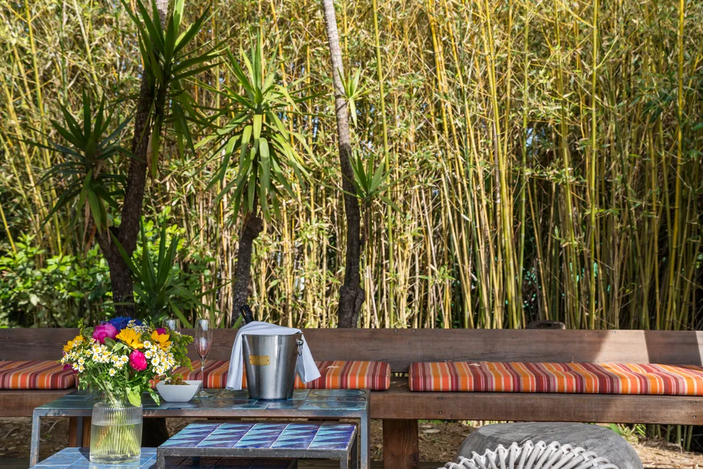 A tiled table set with rosé and a champagne bucket before a bamboo screen