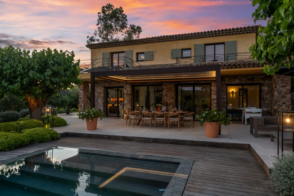 The villa's lit loggia at twilight above the plunge pool, under a coloured sky