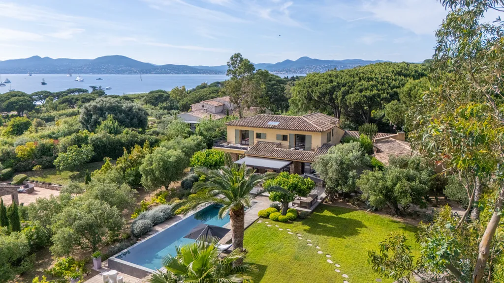 Elevated daytime view of the villa and pool with the bay of Saint-Tropez beyond