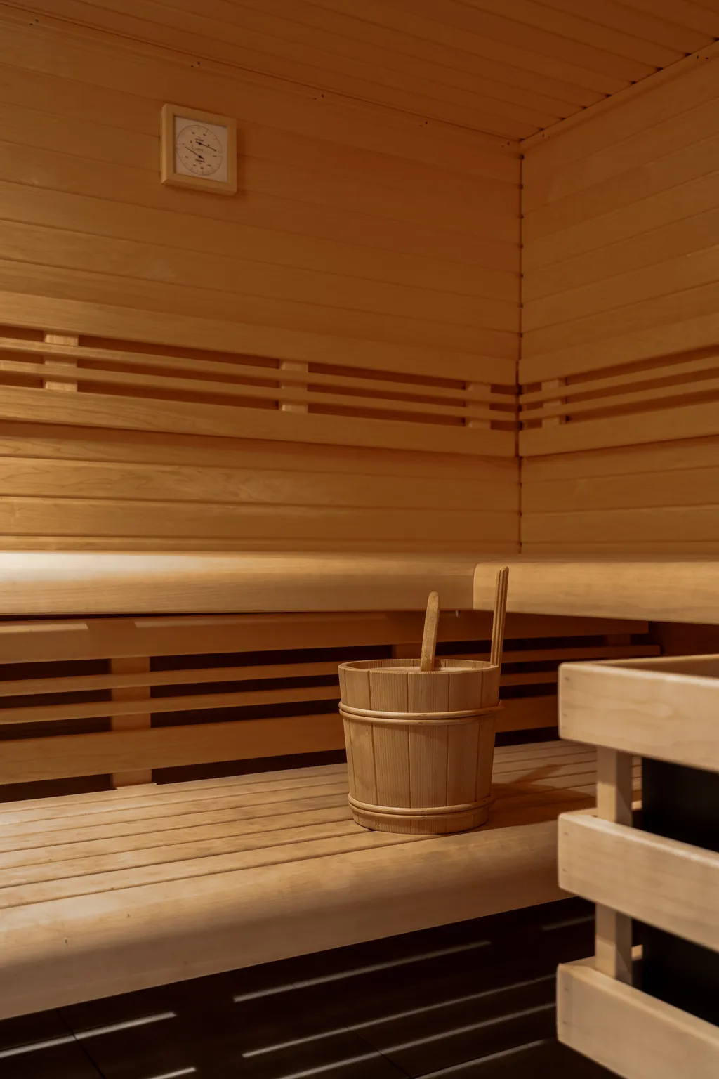 The sauna's timber interior, a bucket and ladle on the bench